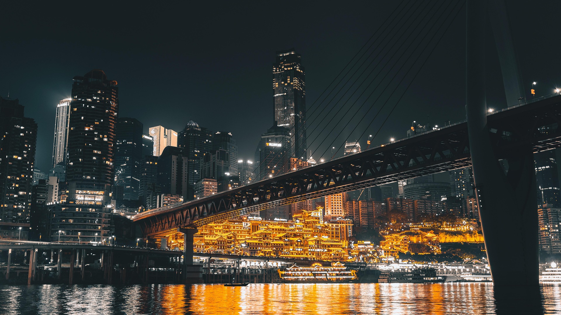 Chongqing at night, the river bridge lit above the old riverside quarter